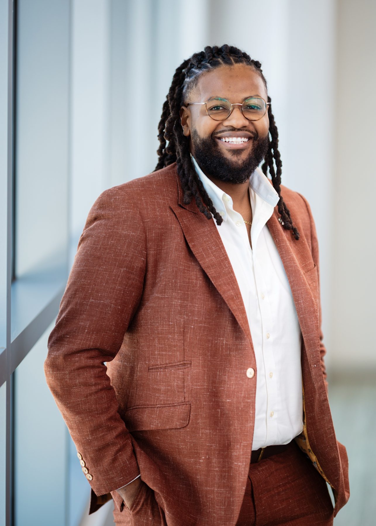 Jerome Smalls smiling in a rust-coloured jacket